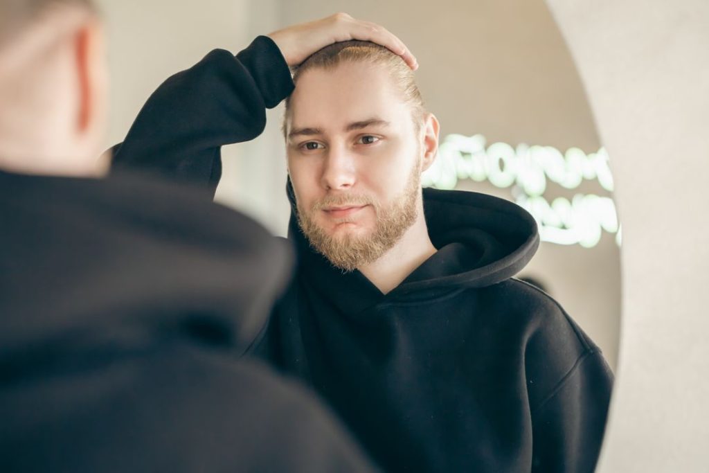 a man looking at himself in the mirror during addictions counseling
