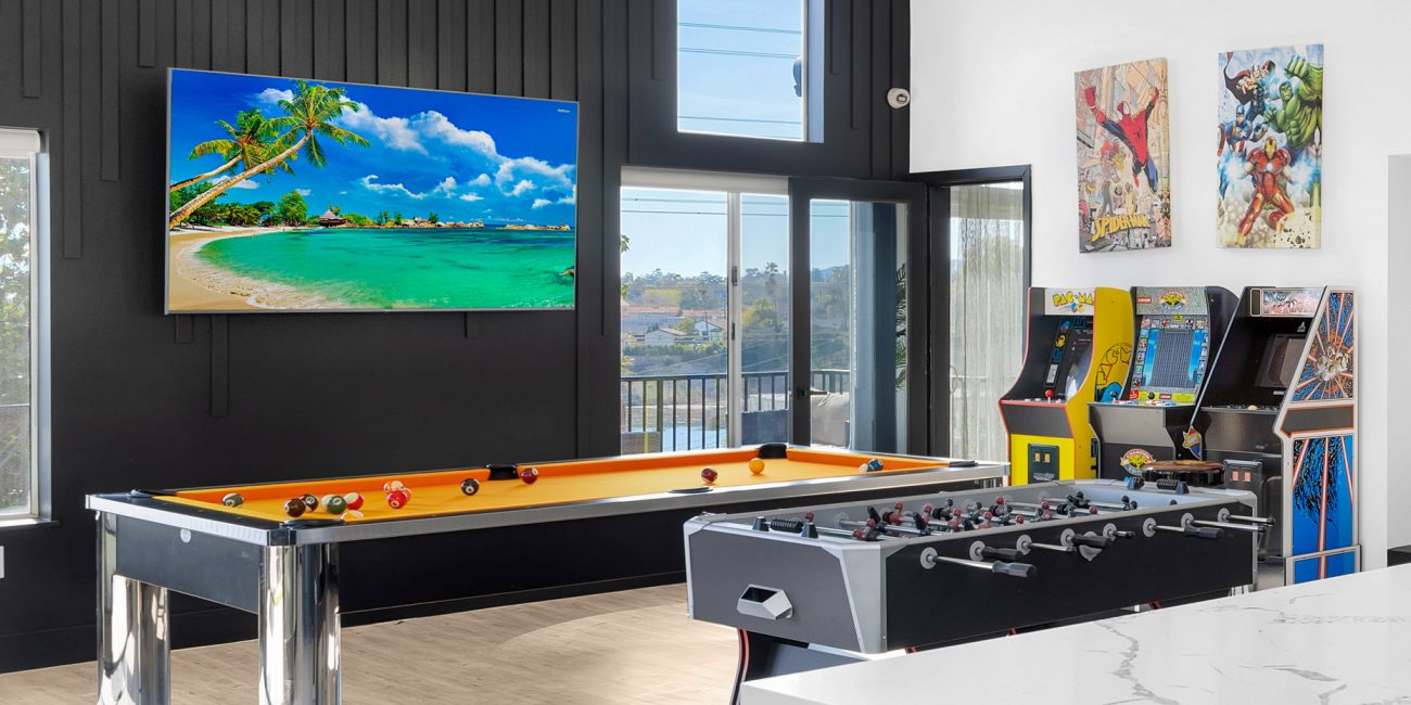 The game room featuring a pool table, foosball table, and arcade games at Uplift Recovery Center