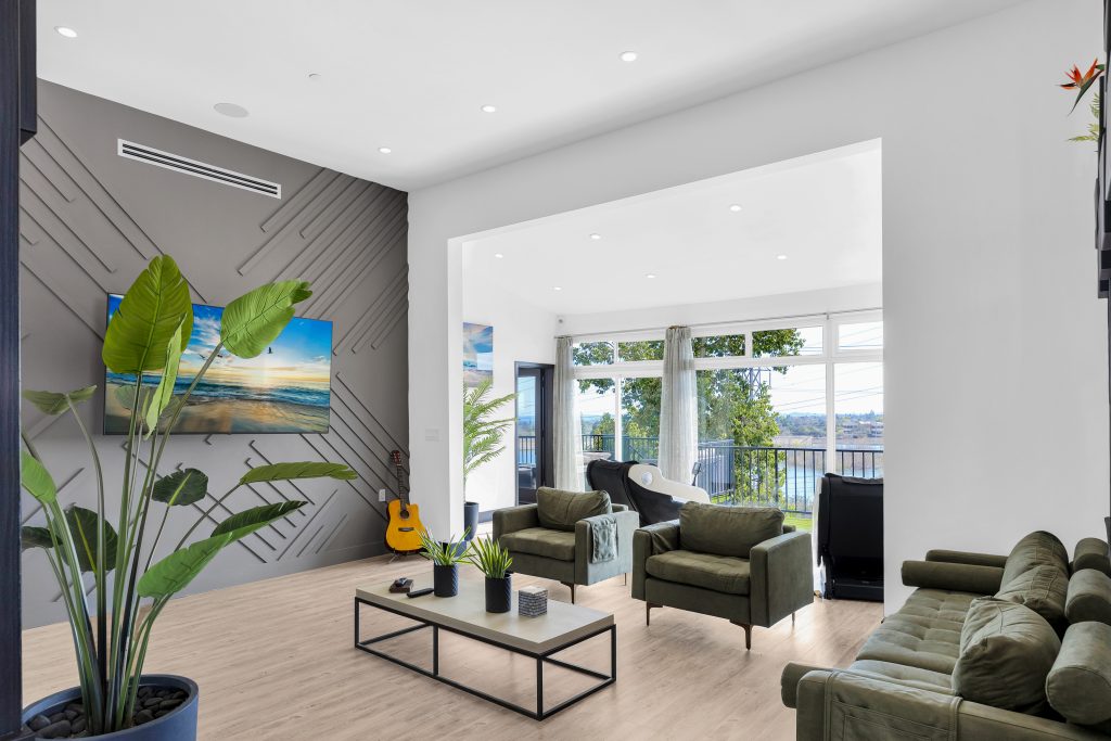 The living room of Uplift Recovery Center facing the tv and massage chairs