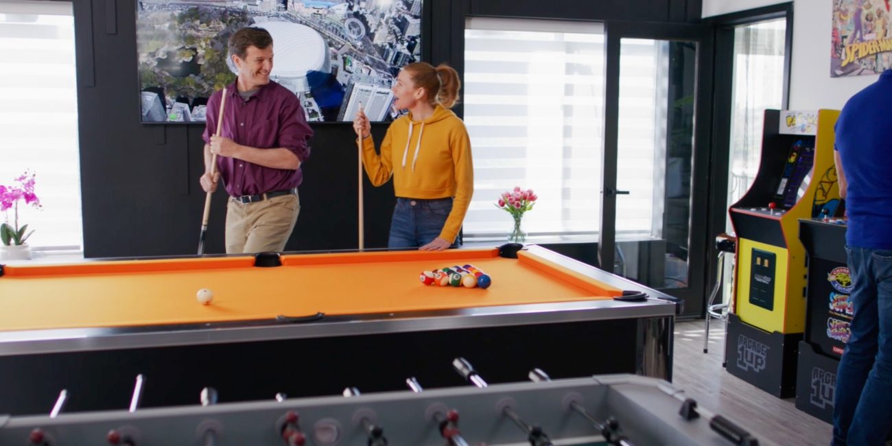 A man and woman playing pool together in the game room at Uplift Recovery Center