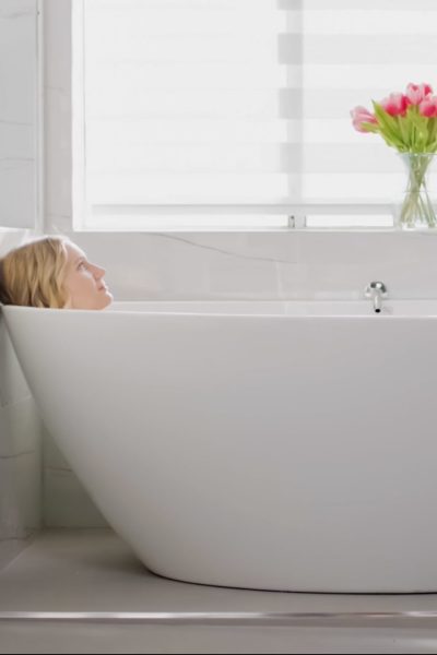 Woman relaxing in a bathtub at Uplift Recovery Center