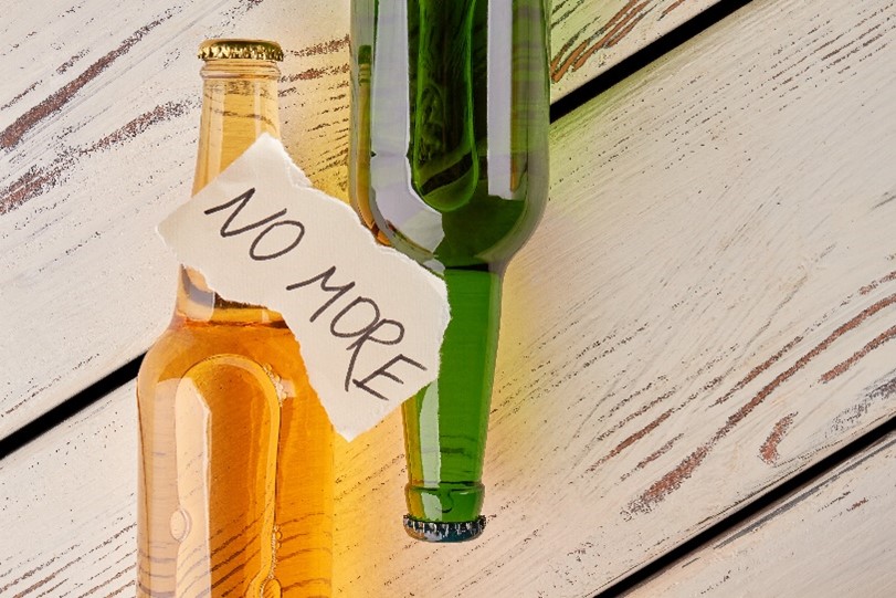 two empty bottles with "no more" written on a piece of paper signifying the end of alcohol abuse