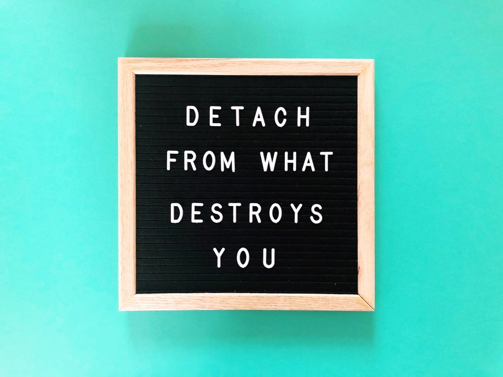 sign that says "detach from what destroys you"