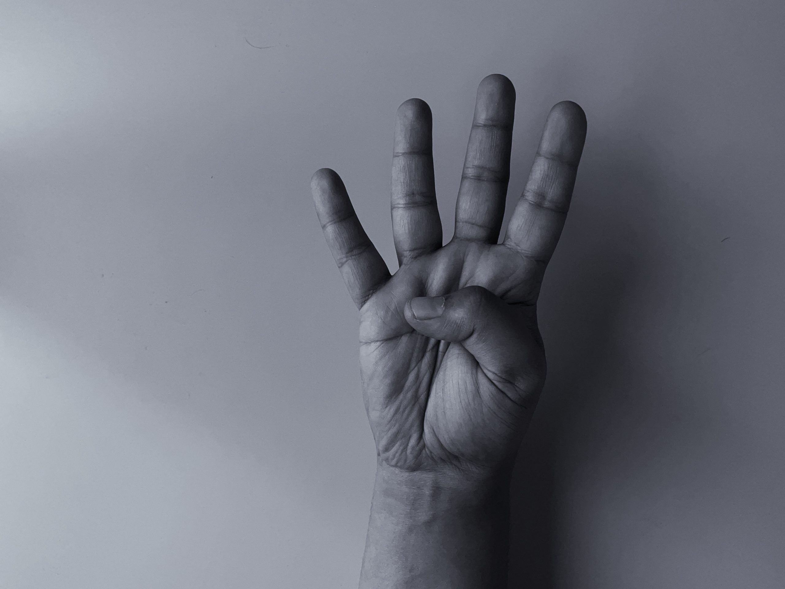 Hand holding up four fingers, representing the cycle of addiction