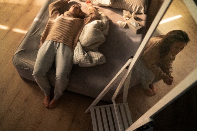 a woman on her bed against on image of herself sitting on the edge of the bed. This signifies cognitive behavioral therapy vs psychotherapy
