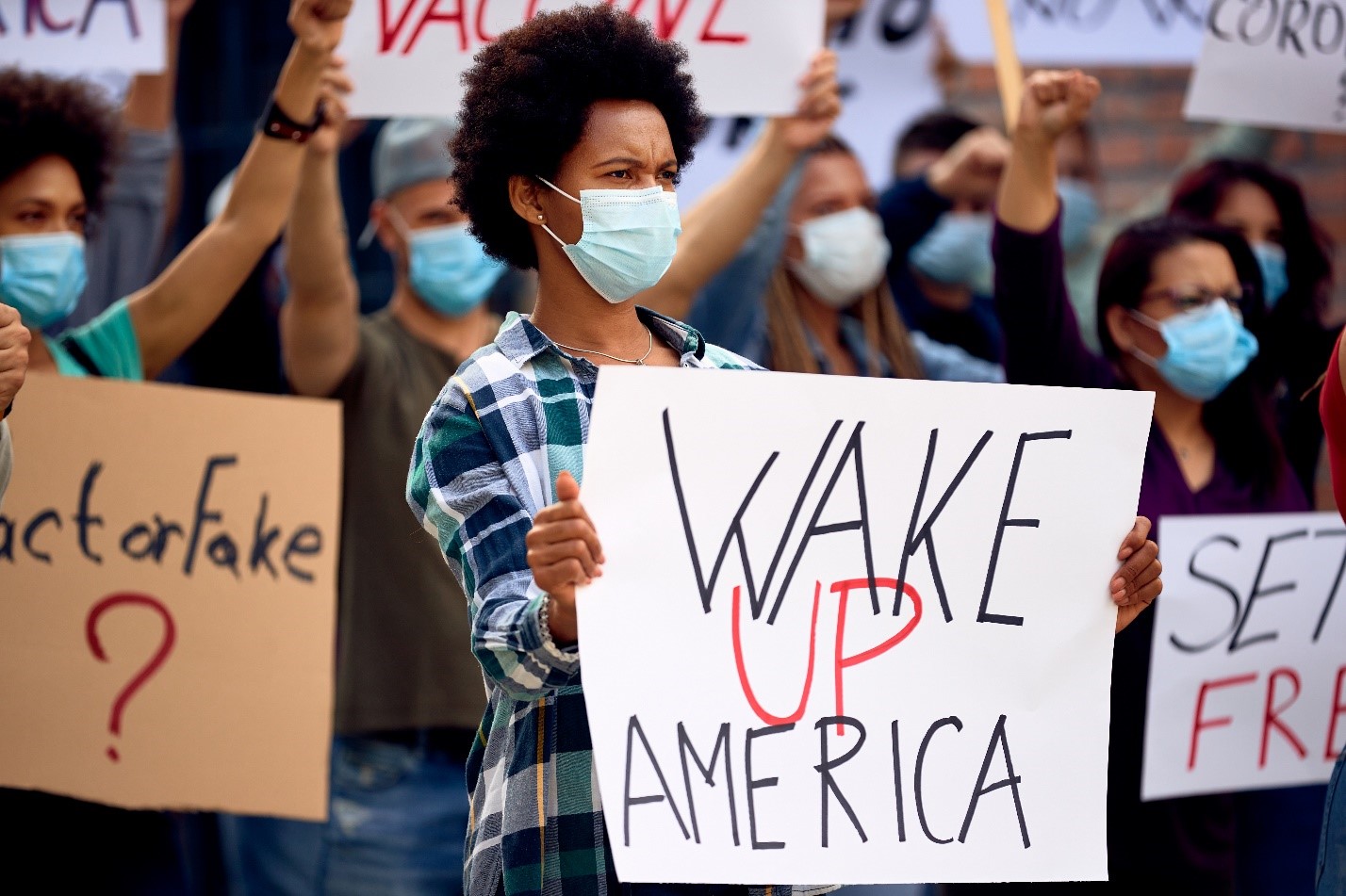 a woman holding a wake up america sign highlighting the alarming statistics about addiction