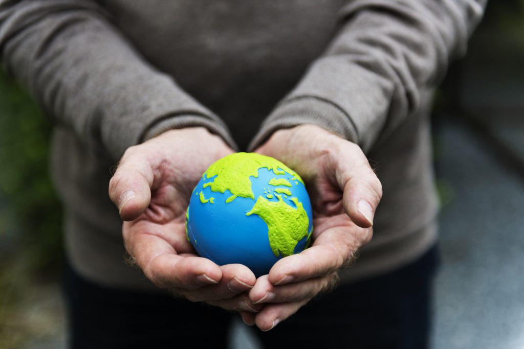 holding a clay globe of Earth, representing International Overdose Awareness Day