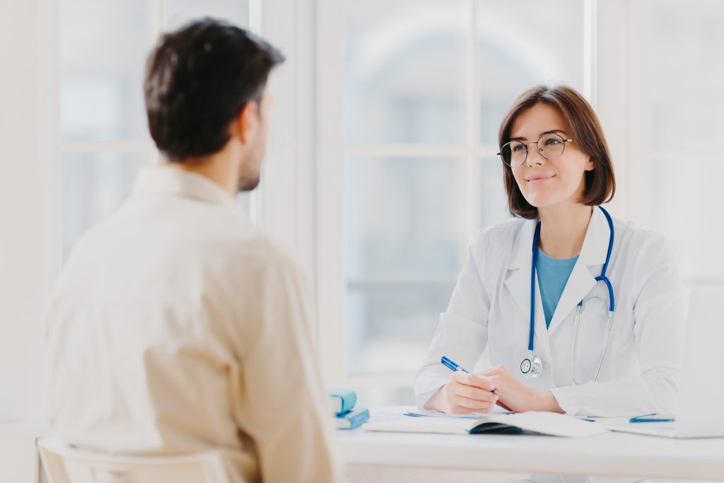 a patient talking to a doctor trying to decide between detox vs rehab