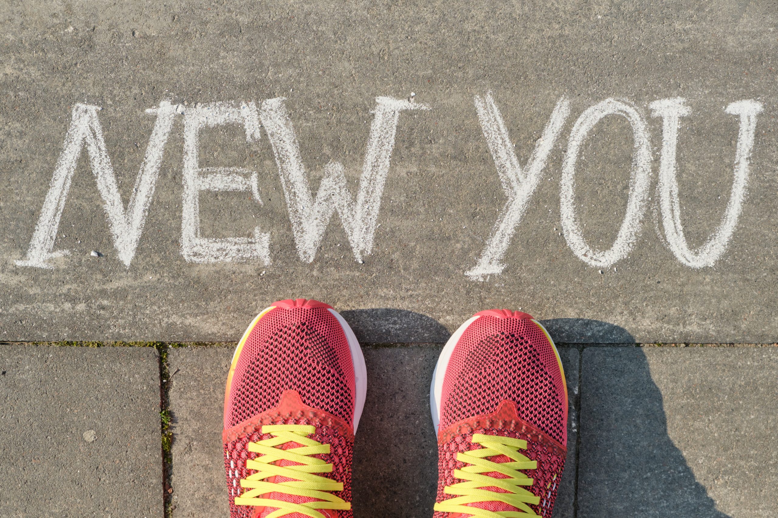 "new you" written on a sidewalk in front of a pair of red sneakers. This highlights the importance of National Sober Day