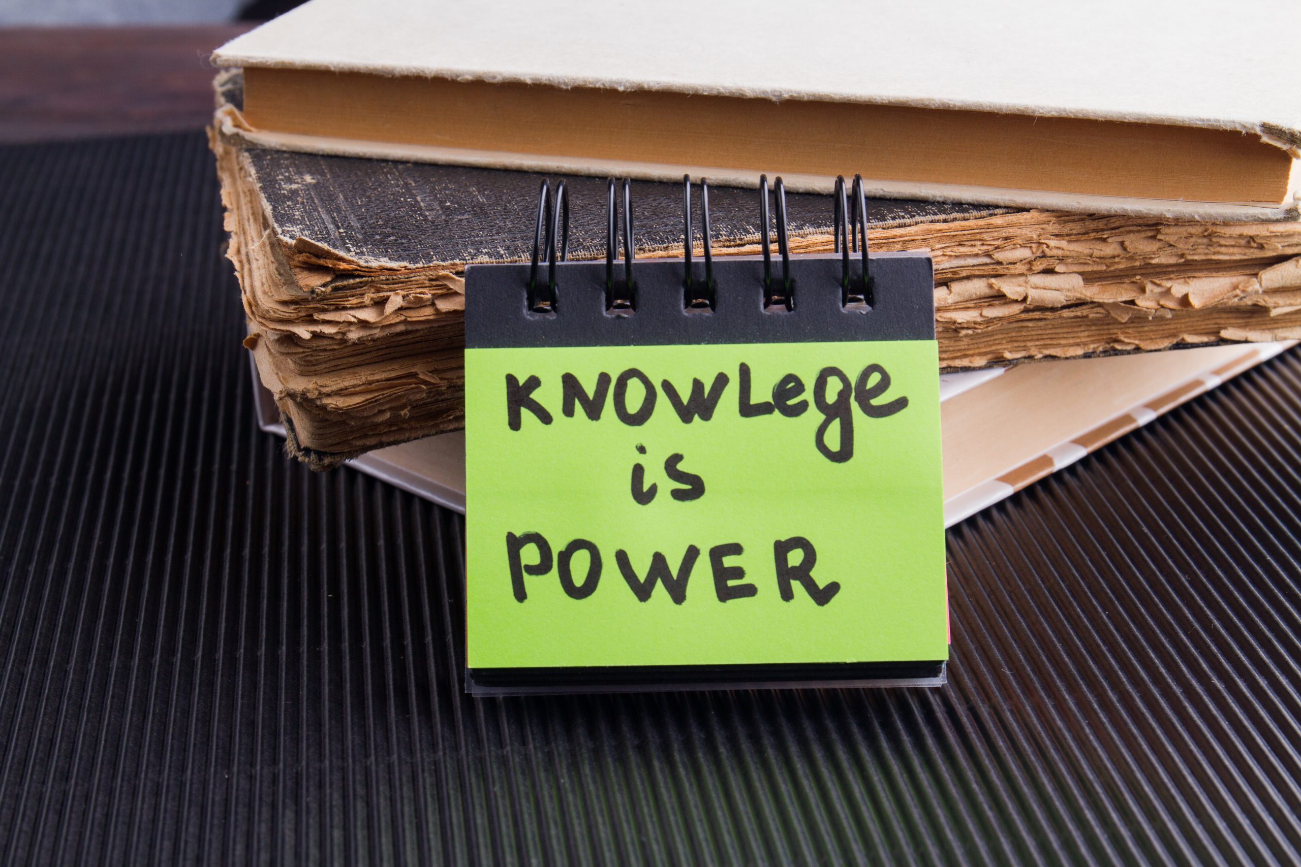 notebooks with a sticky note that reads "knowledge is power", referring to knowing the most addictive drug