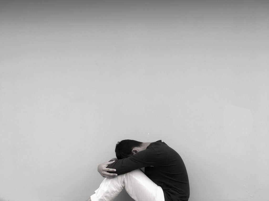 black and white photo of man depressed as he has battled with binge drinking vs alcoholism