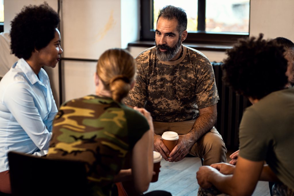 group of veterans talking during a therapy session about veterans and addiction
