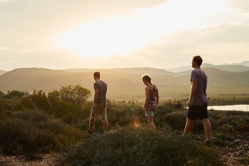 3 hikers on a mountain trail as part of adventure therapy