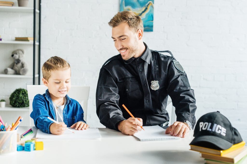 A police officer drawing with a child happily during Law Enforcement Appreciation Day