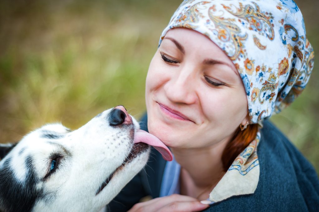 a dog licking a woman's face as part of animal assisted therapy