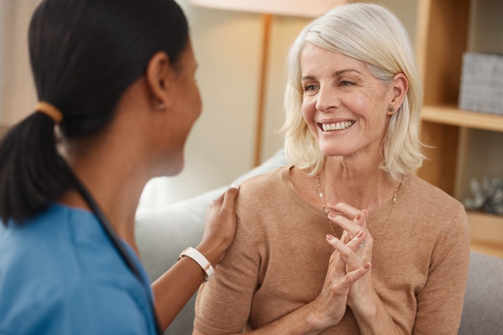 a doctor siting with an older patient discussing "does Medicare cover rehab?"