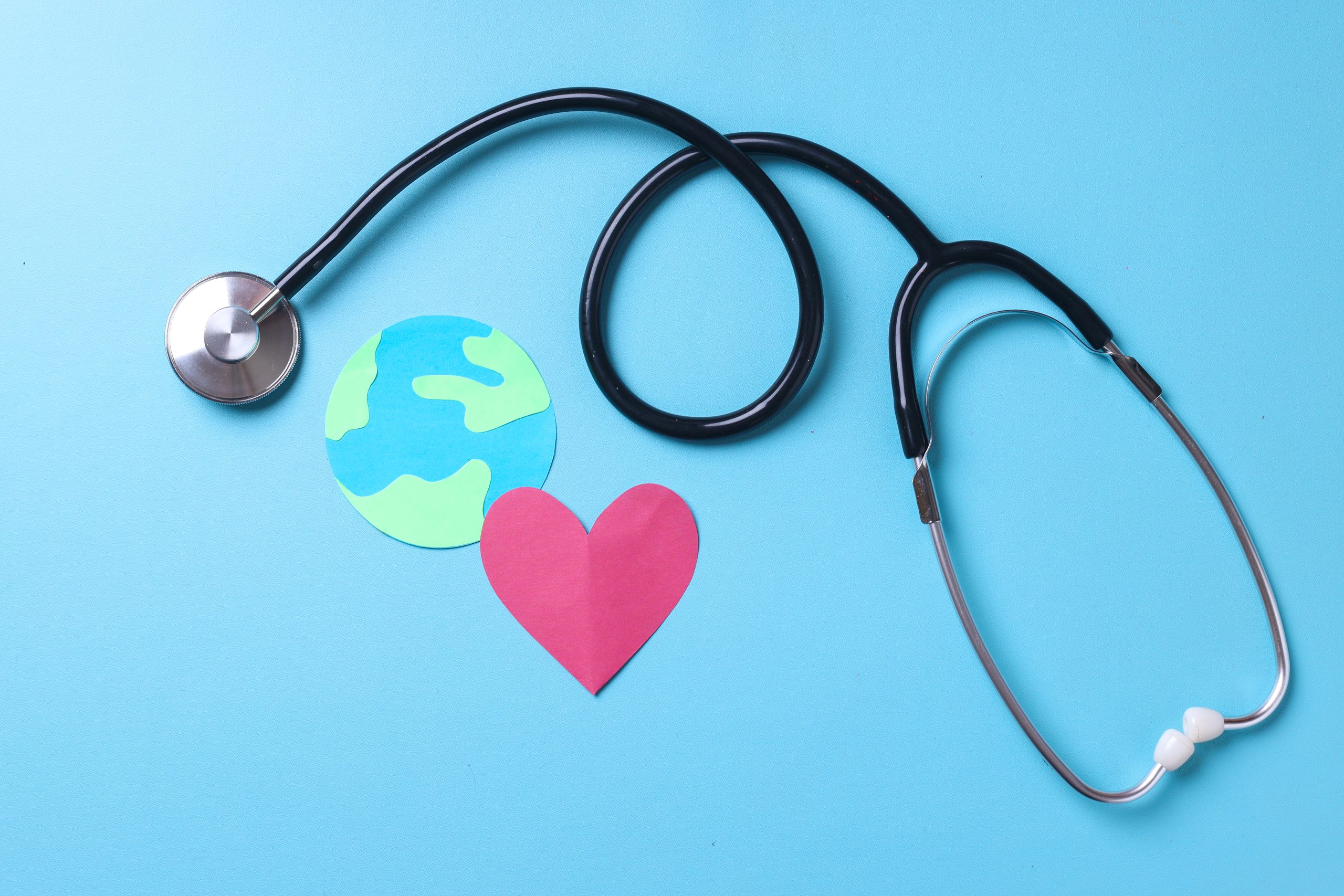 a globe , a red heart, and a stethoscope on a blue background symbolizing World Health Day