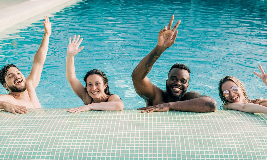 4 people raising their hands in happiness as they are going through aquatic therapy for addiction recovery