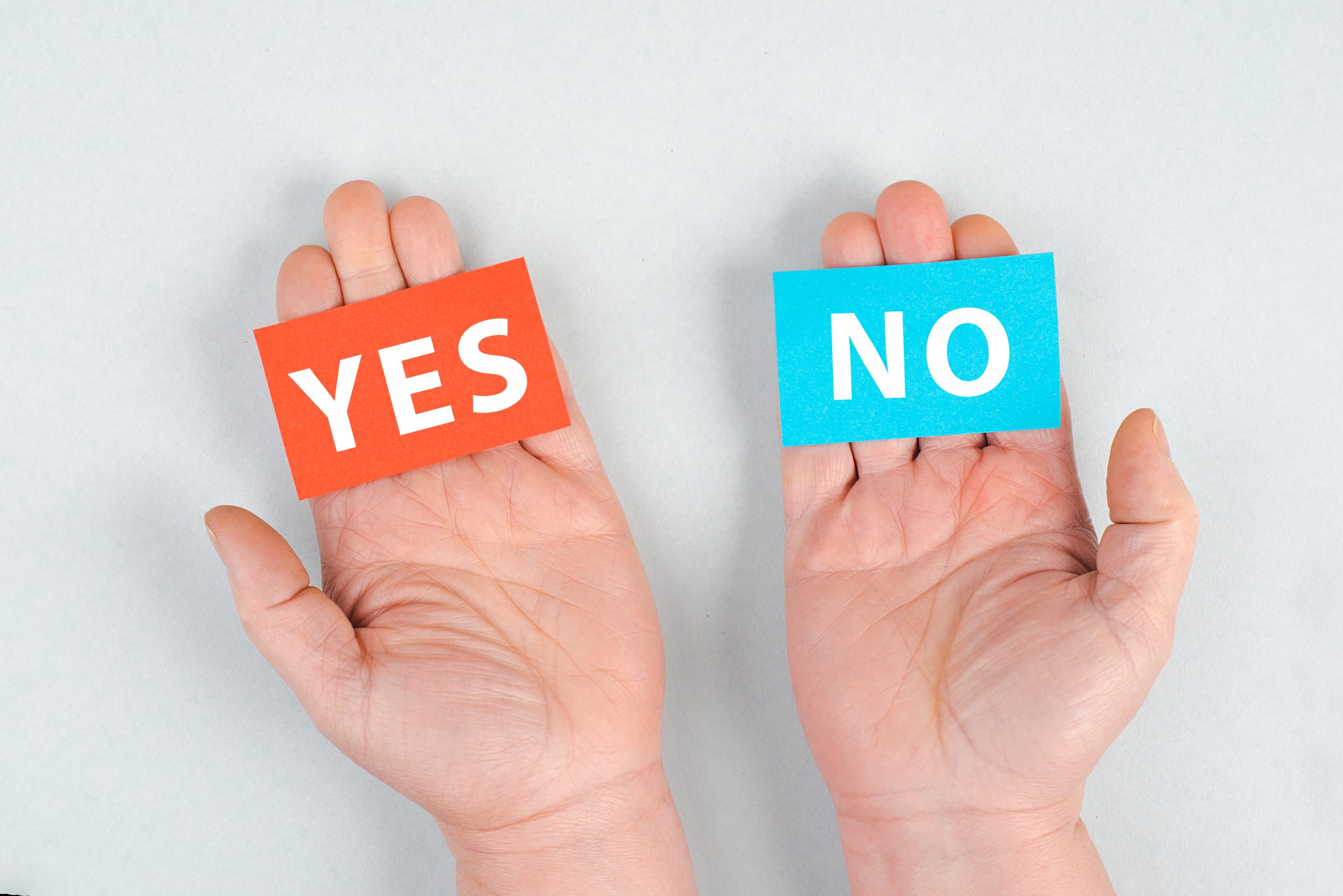 open palms holding "yes" and "no" on sticky notes, begging the question "can you drink rubbing alcohol"?