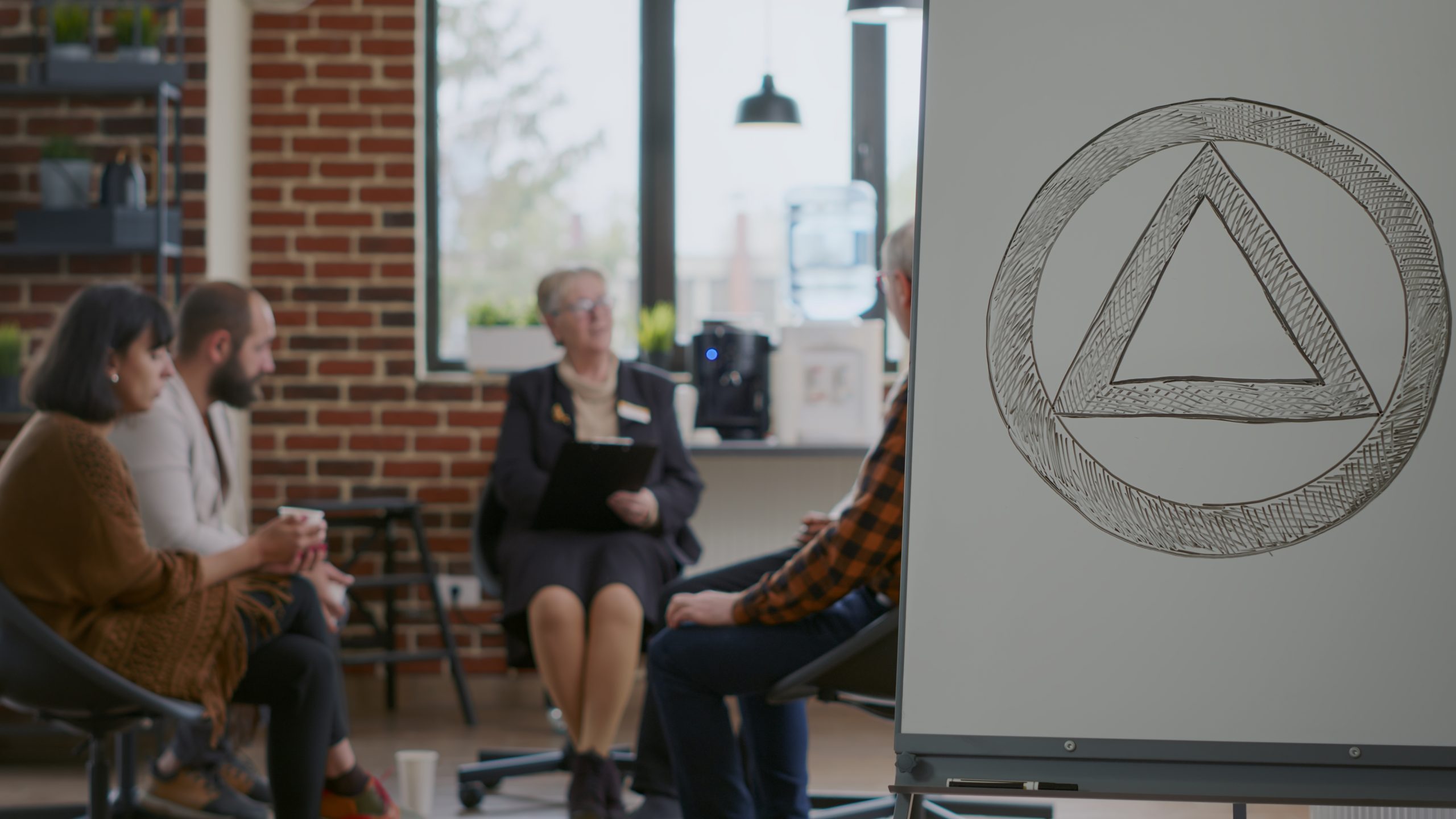 a woman leading an AA meeting, showing how to be an AA sponsor