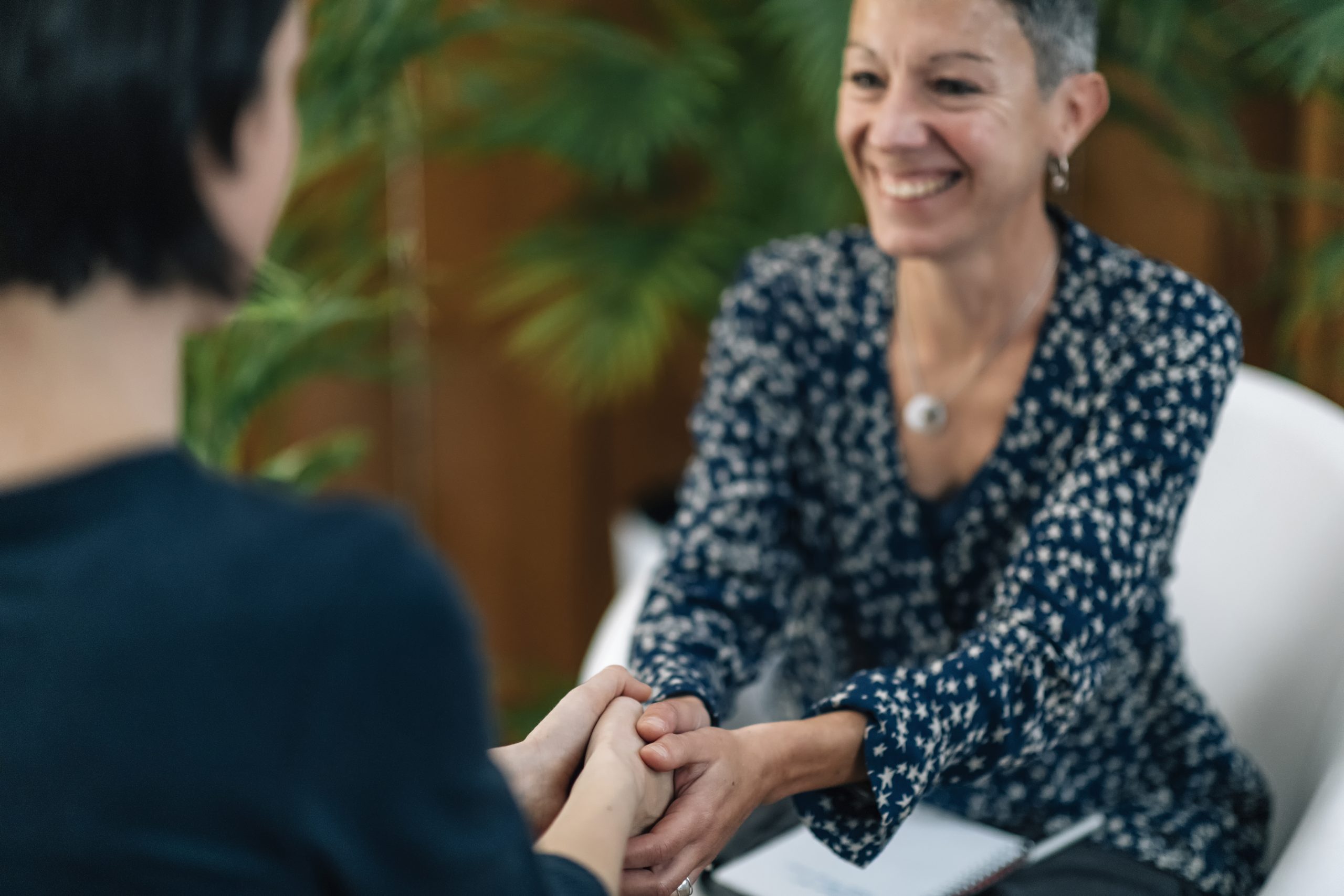 a drug counselor embracing hands with her patient